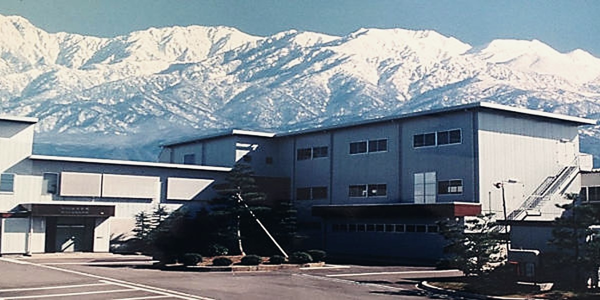 Yamamori factory in Toyama with snow-capped mountains behind